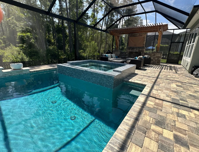 Swimming pool with attached spa, outdoor patio with seating, and screen enclosure.