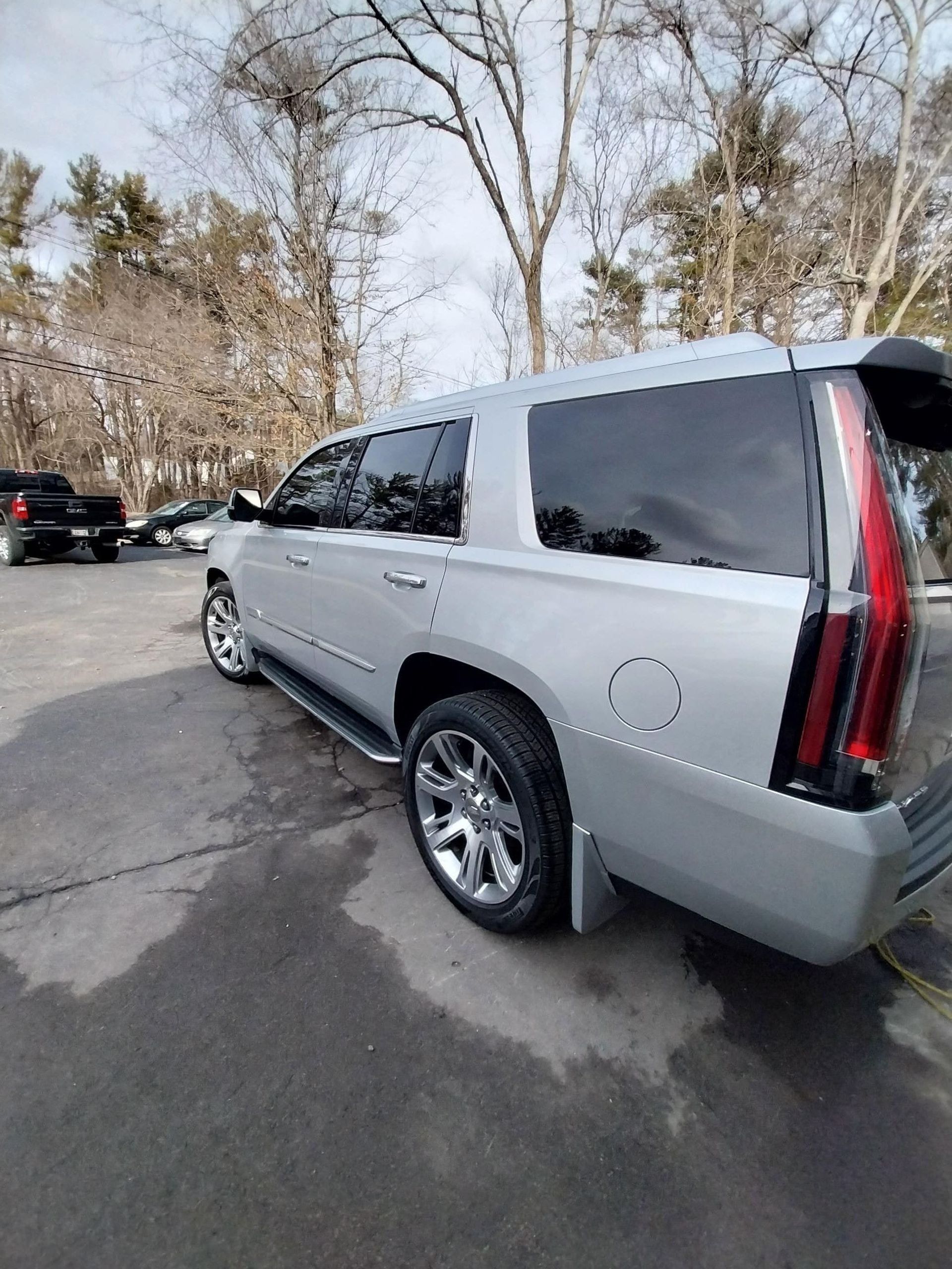 Silver Cadillac SUV parked outside.