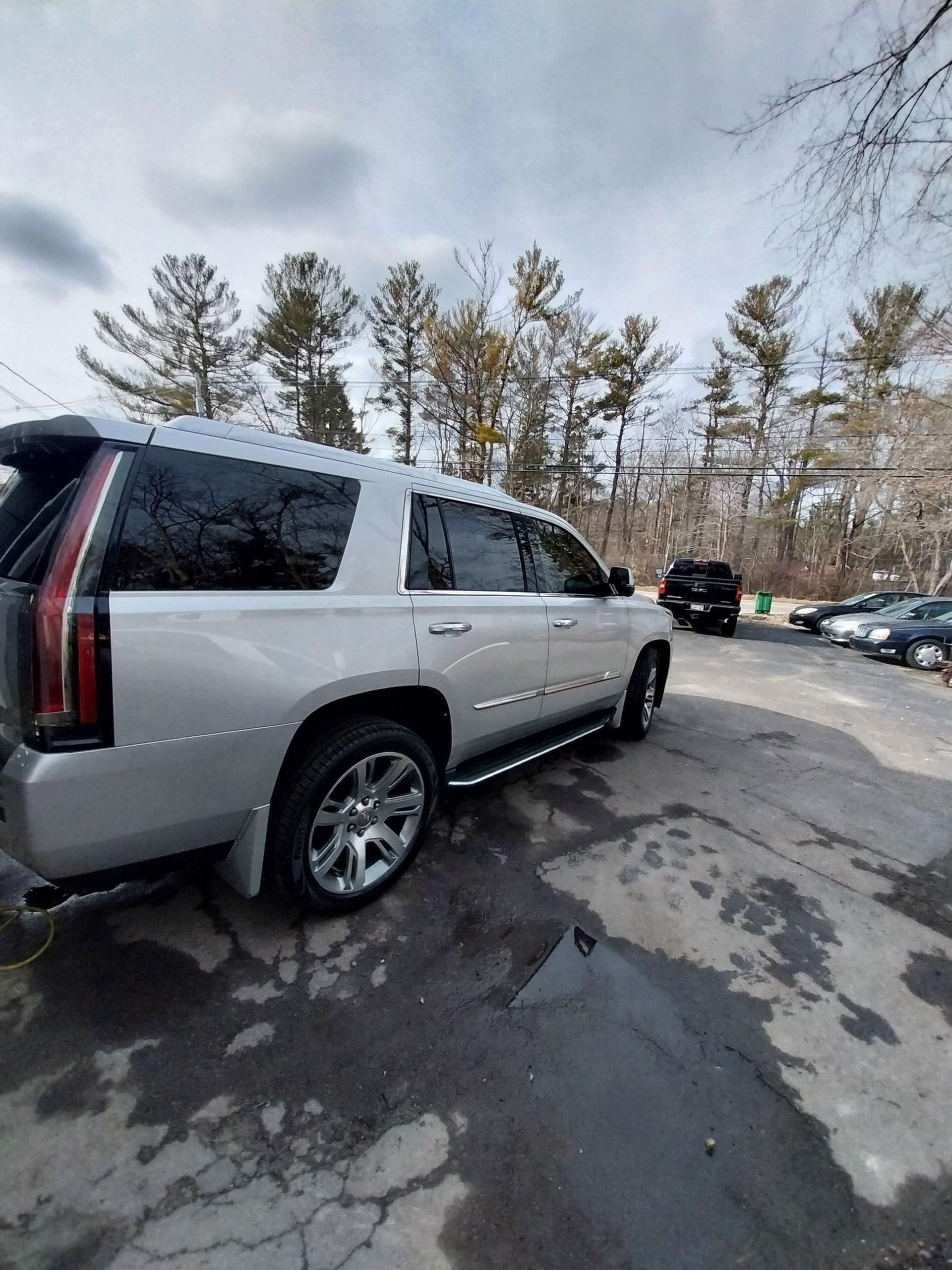 Silver Cadillac SUV parked outside.