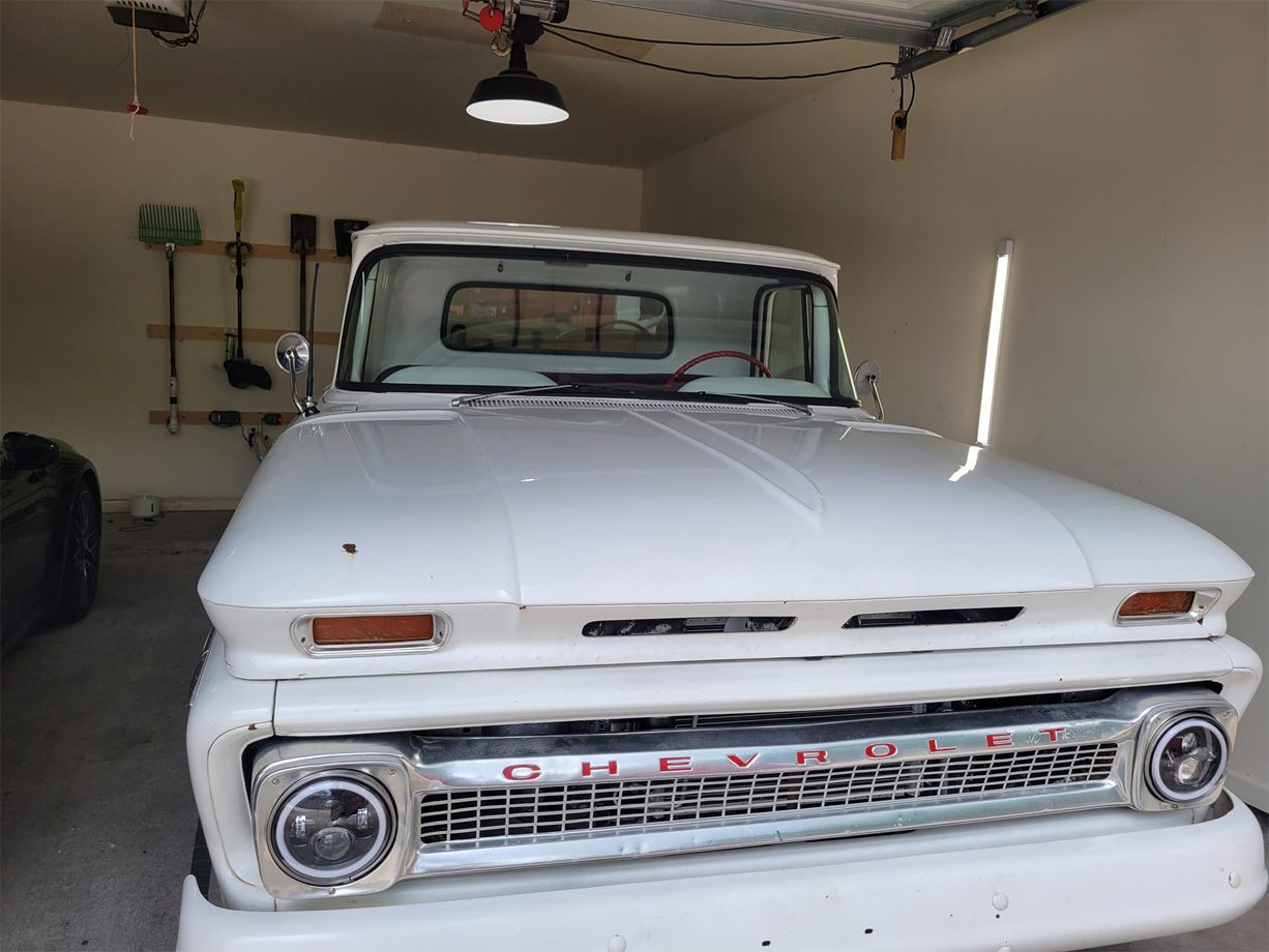 A white pickup truck is parked in a garage.