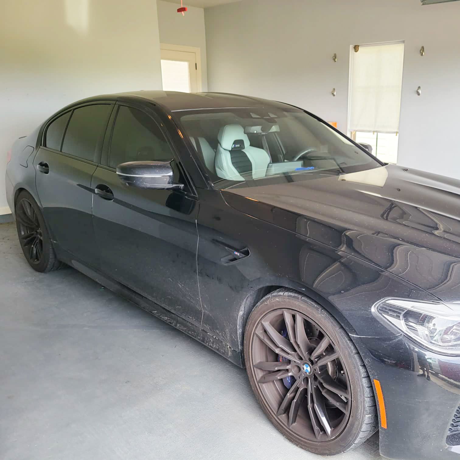 A black car is parked in a garage.