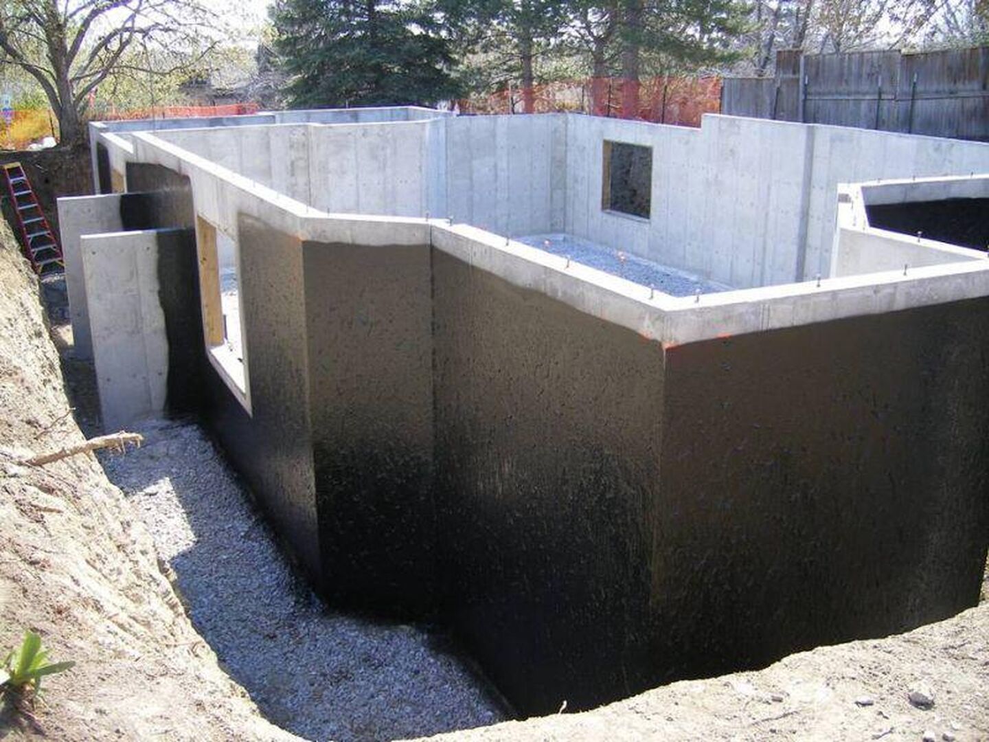 A concrete basement is being built in a dirt area.