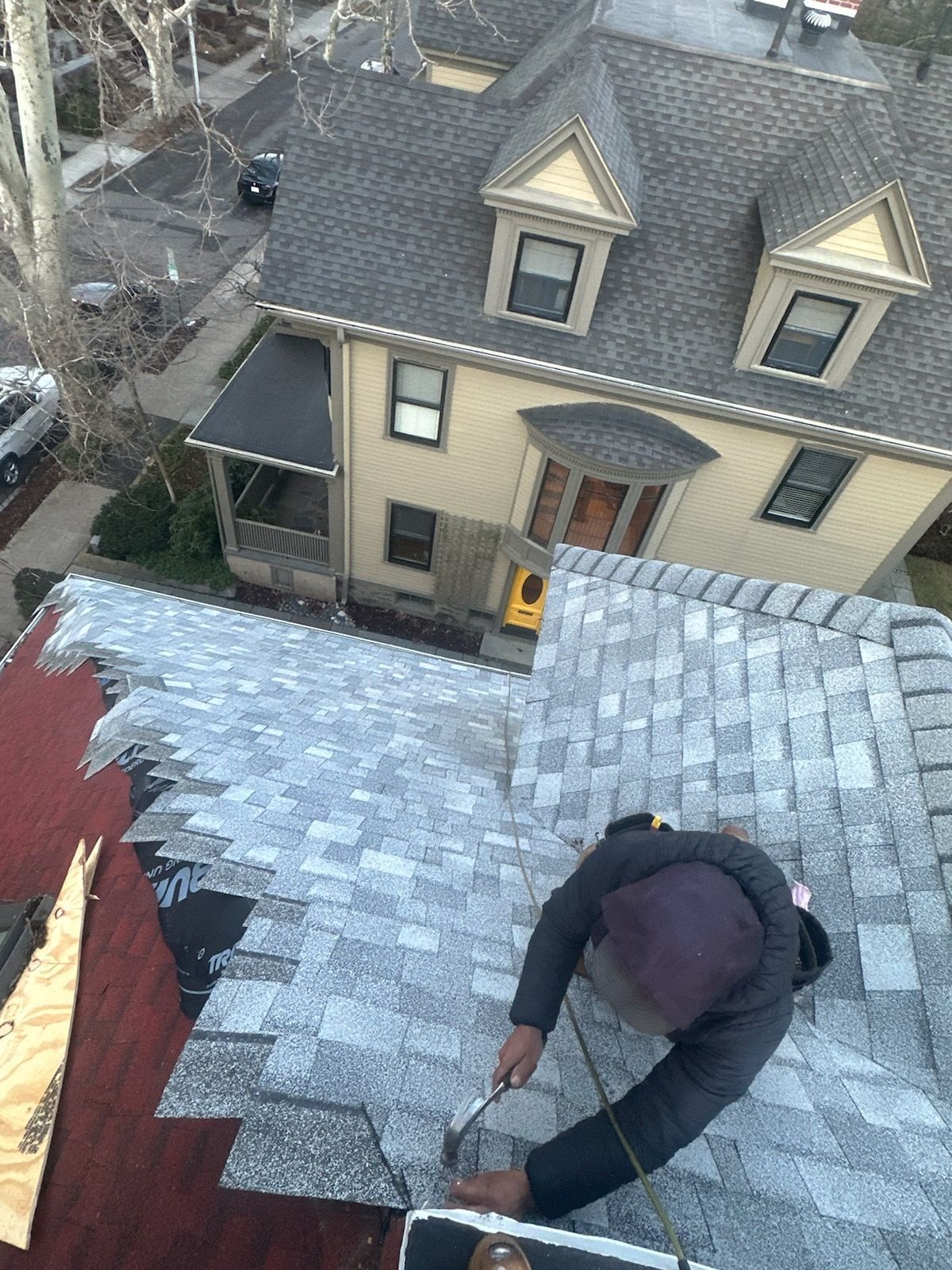 A man is working on the roof of a house.