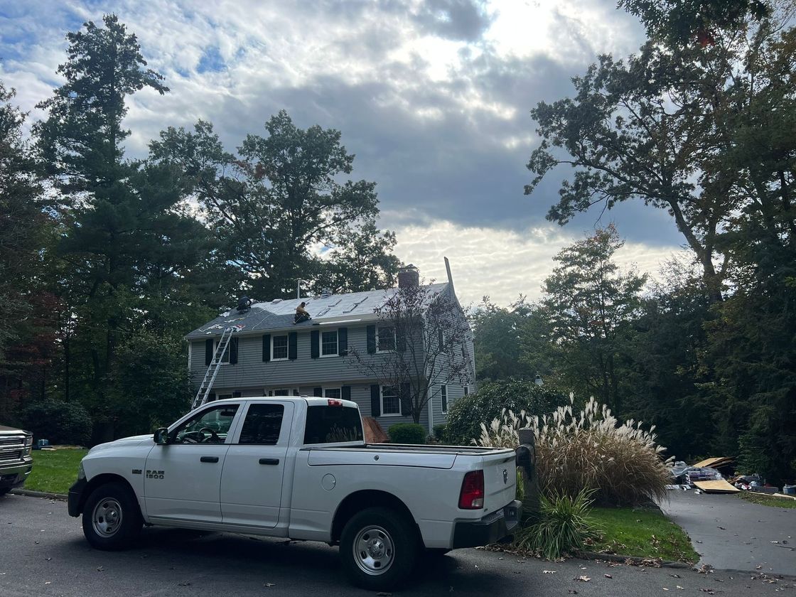 A white truck is parked in front of a house.