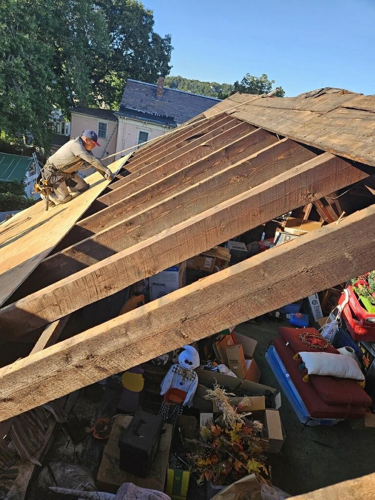 A man is working on the roof of a house.