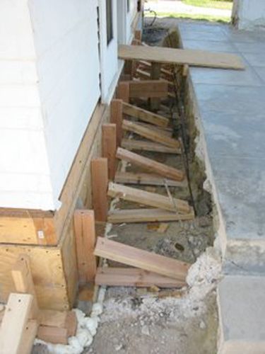 A row of wooden boards are sitting on the ground next to a building.