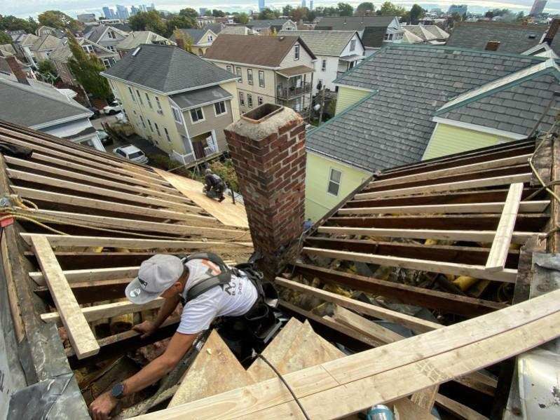 A man is working on the roof of a house.