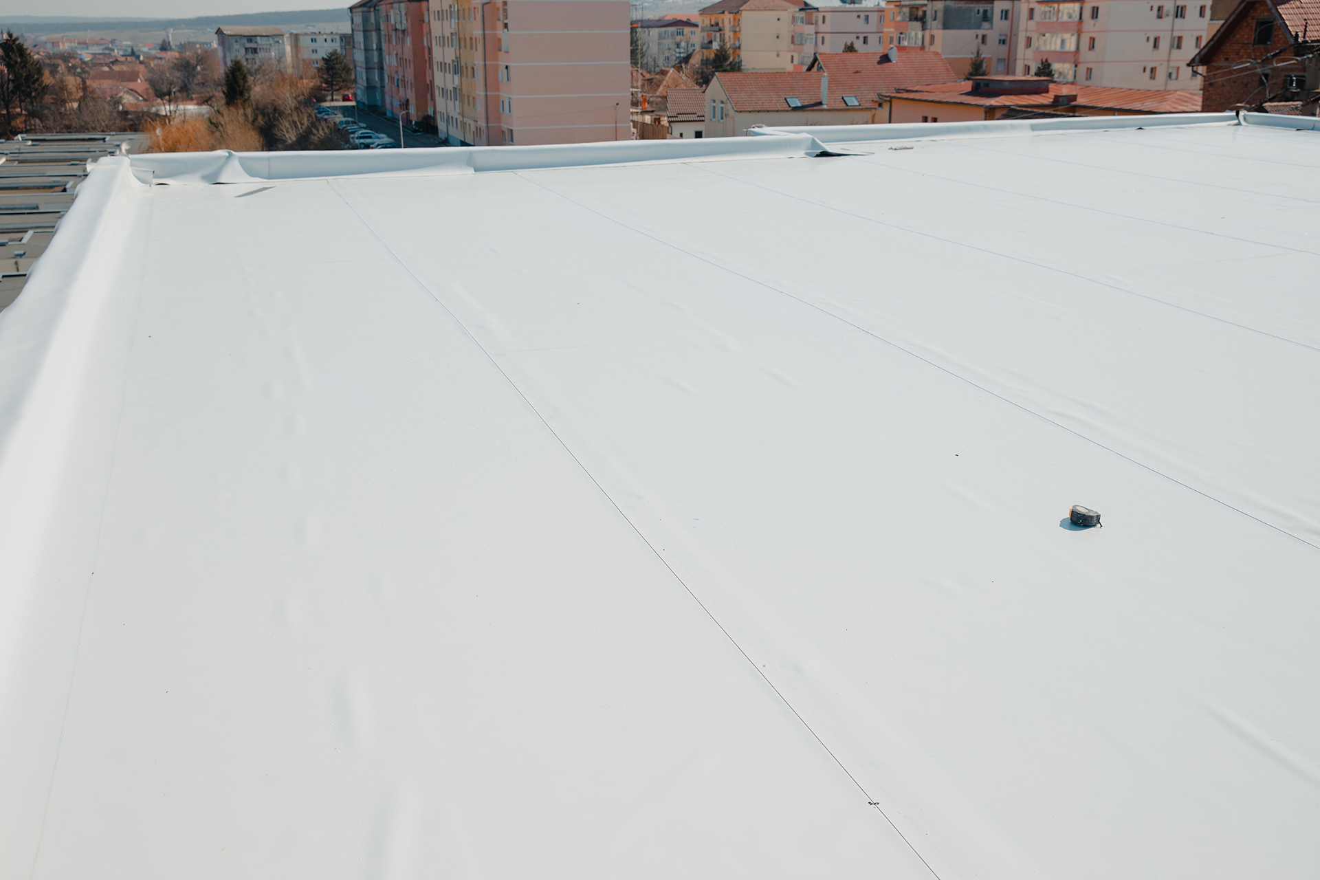 A white roof with a view of a city in the background.