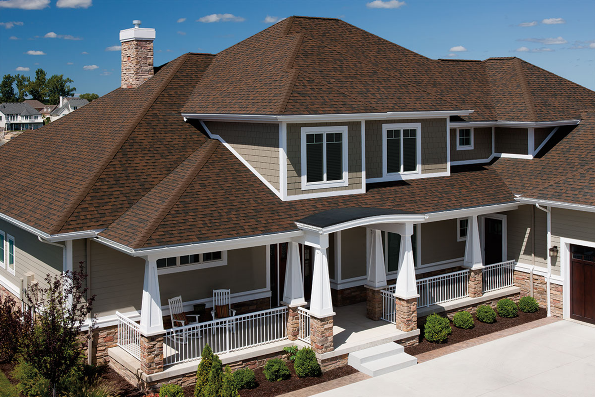 A large house with a brown roof and a large porch