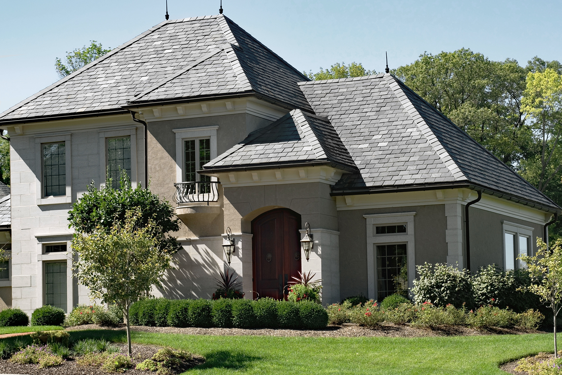 A large house with a gray roof and a balcony