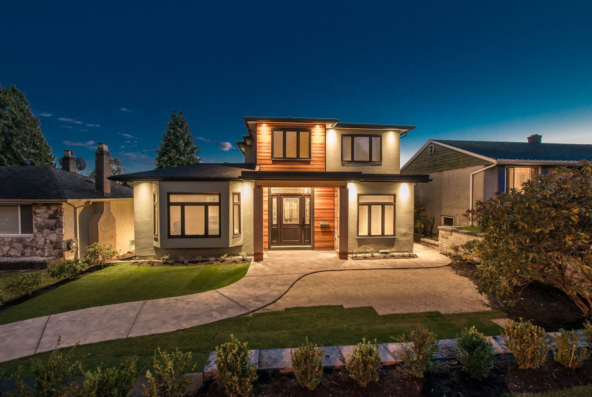 A large house with a lot of windows is lit up at night.