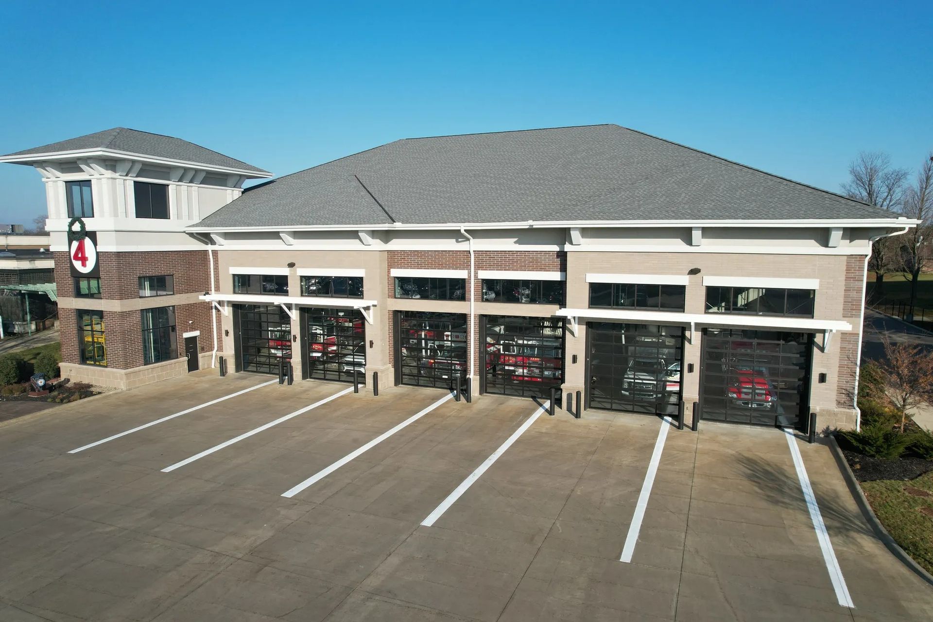 Fire station with four garage bays and empty parking lot on a sunny day