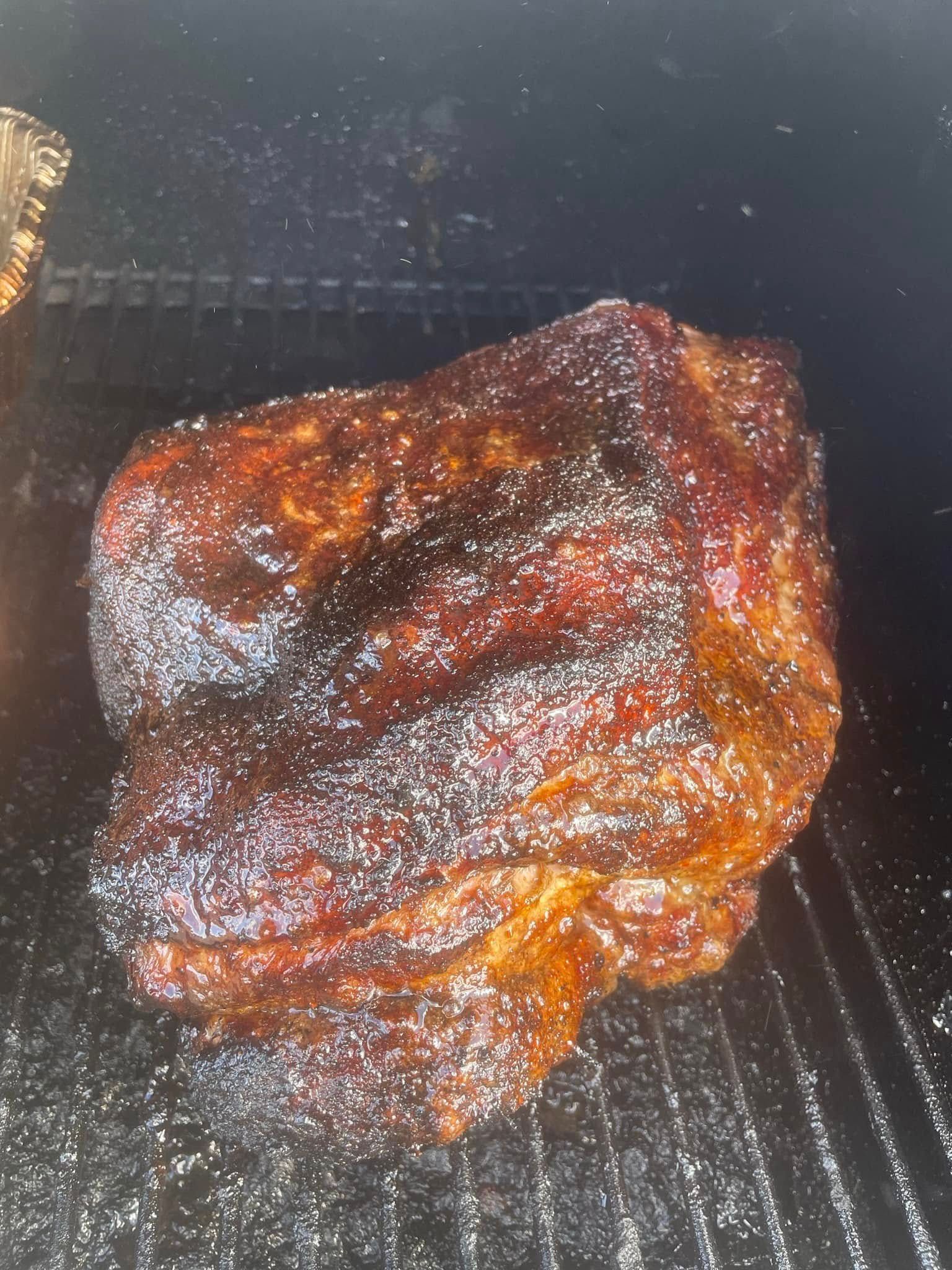 A large piece of meat is cooking on a grill.