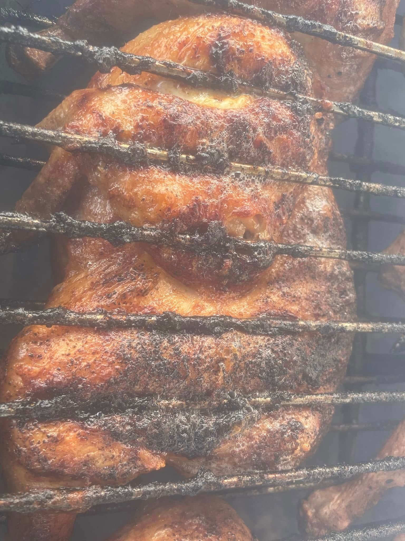 A close up of chicken cooking on a grill.
