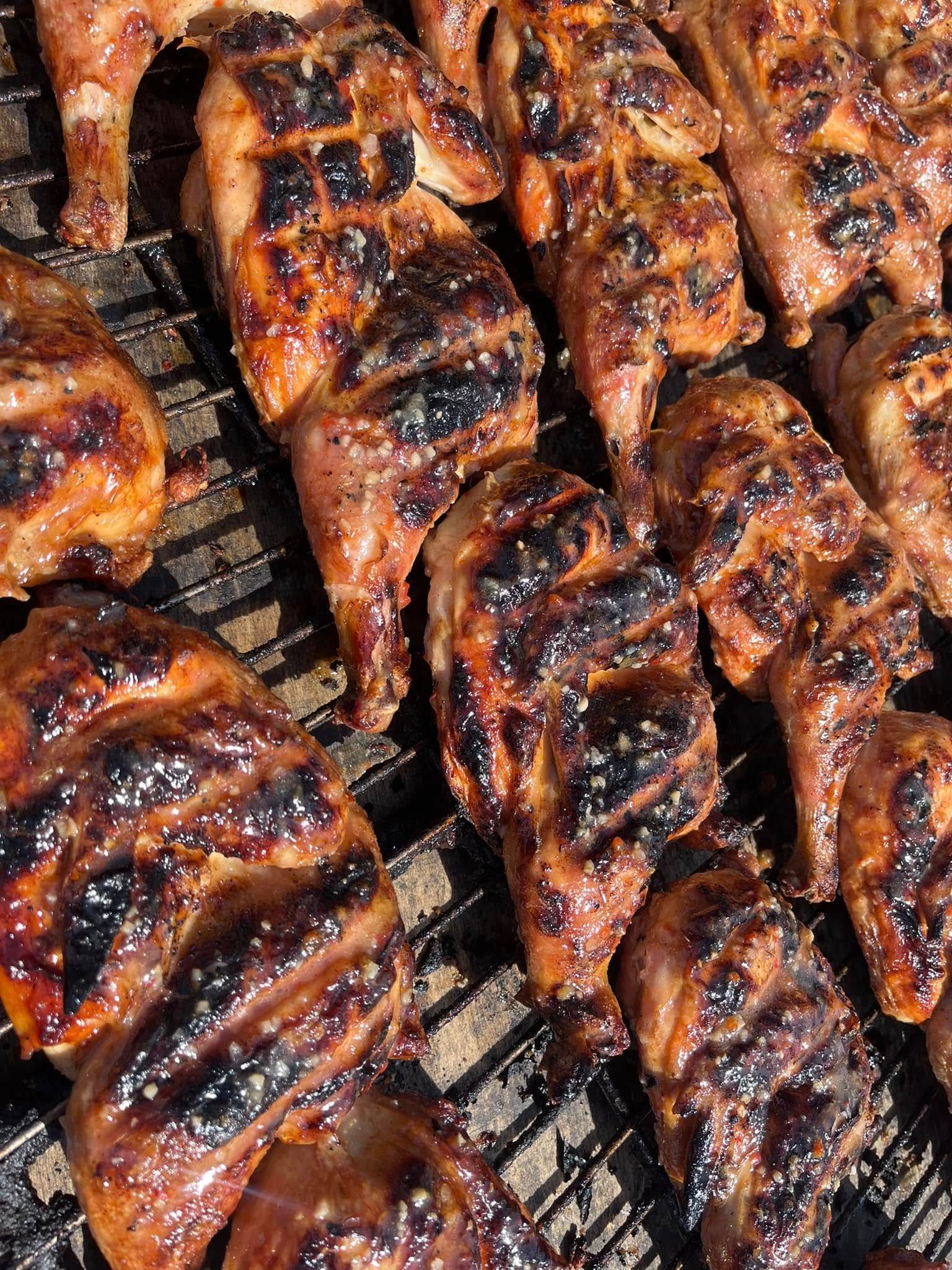A close up of grilled chicken on a grill.