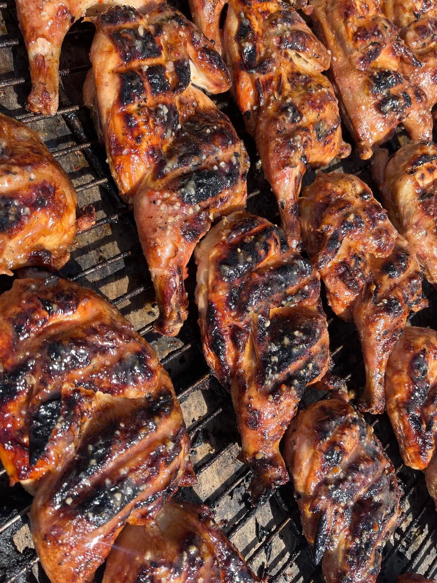A close up of grilled chicken on a grill.