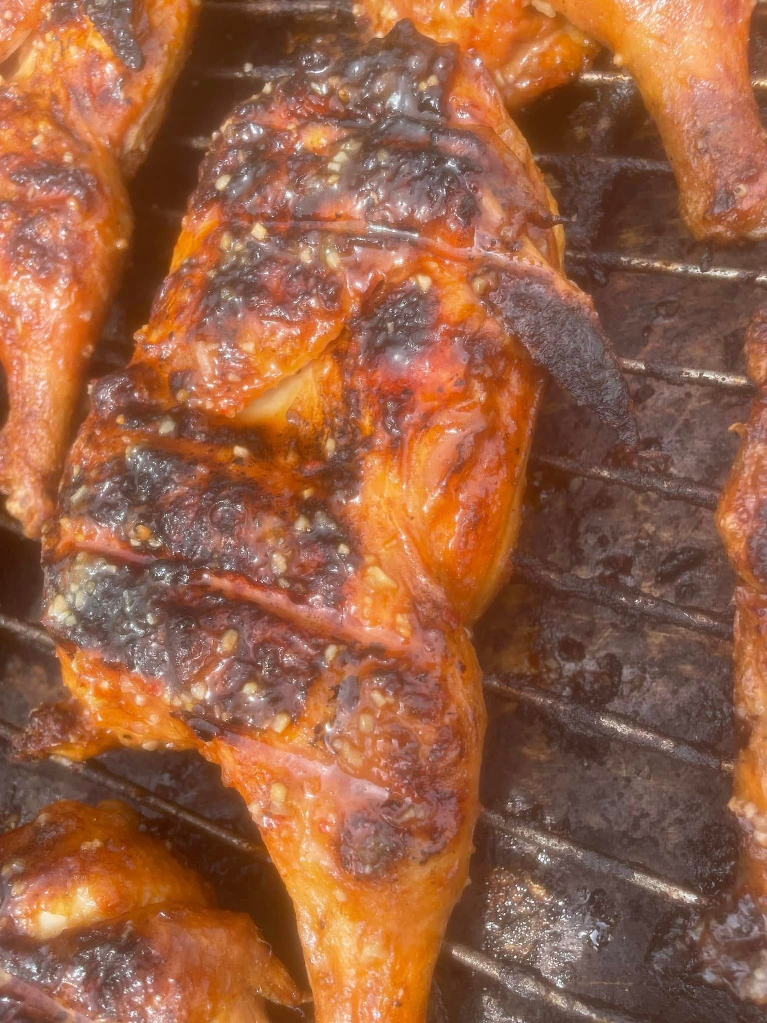 A close up of grilled chicken on a grill.
