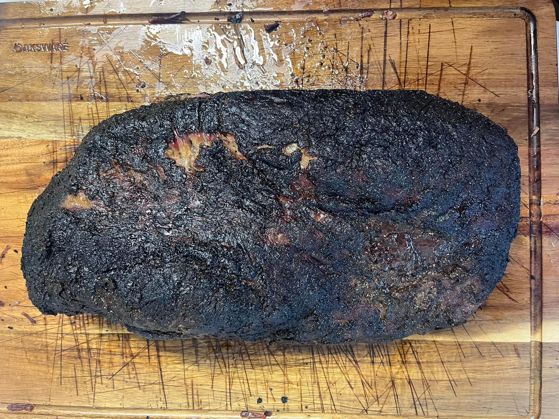 A large piece of meat is sitting on a wooden cutting board.