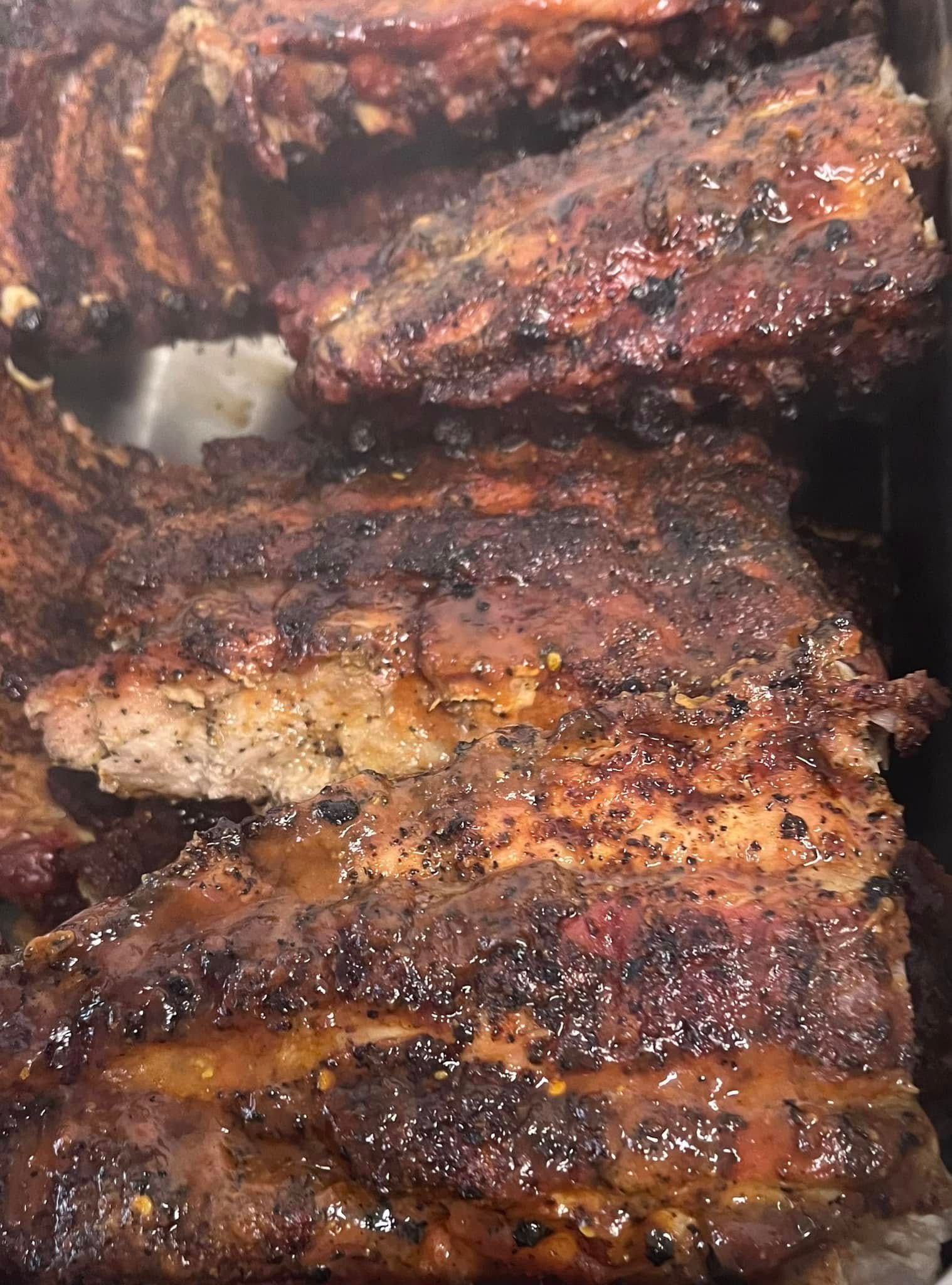 A close up of grilled pork ribs in a pan.