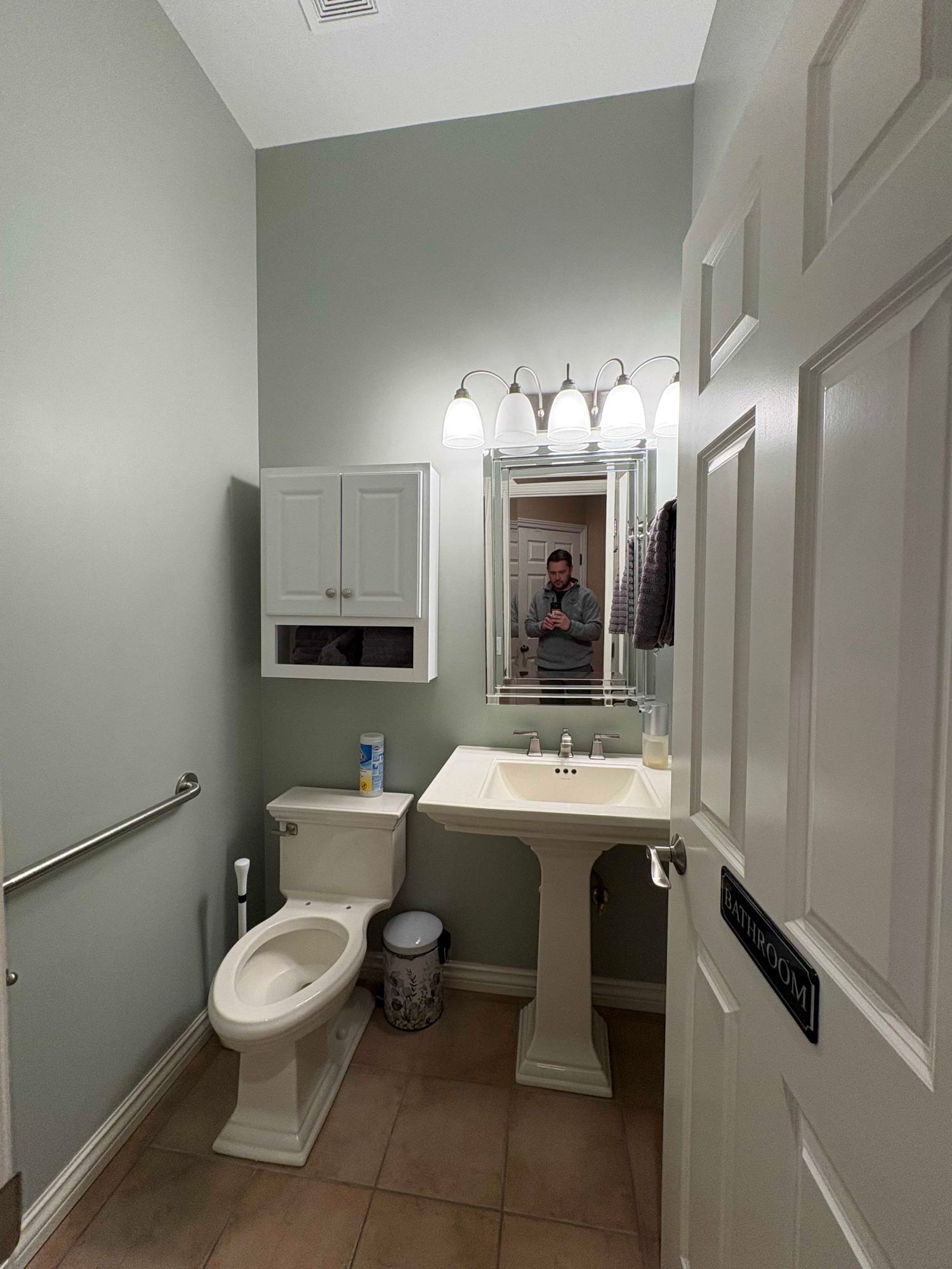 A bathroom with a toilet , sink and mirror.