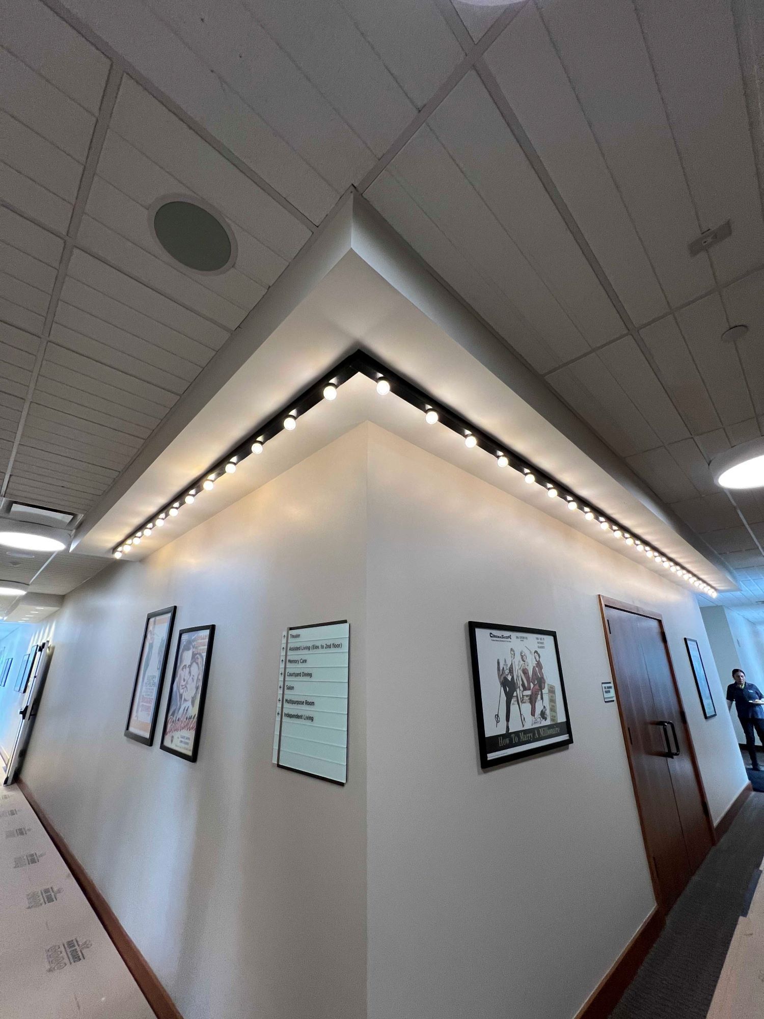 A hallway with pictures on the wall and a ceiling