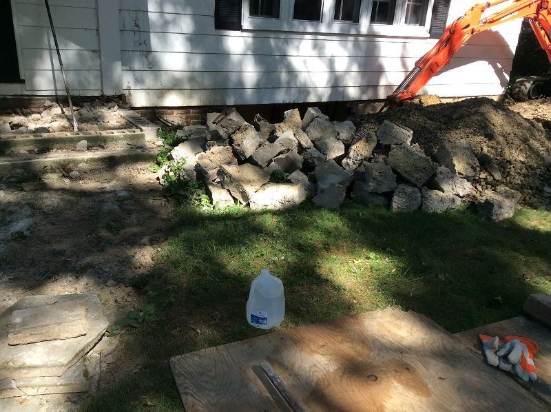 A gallon of water is sitting in the grass in front of a house.