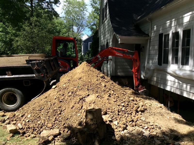A pile of dirt is sitting in front of a house.