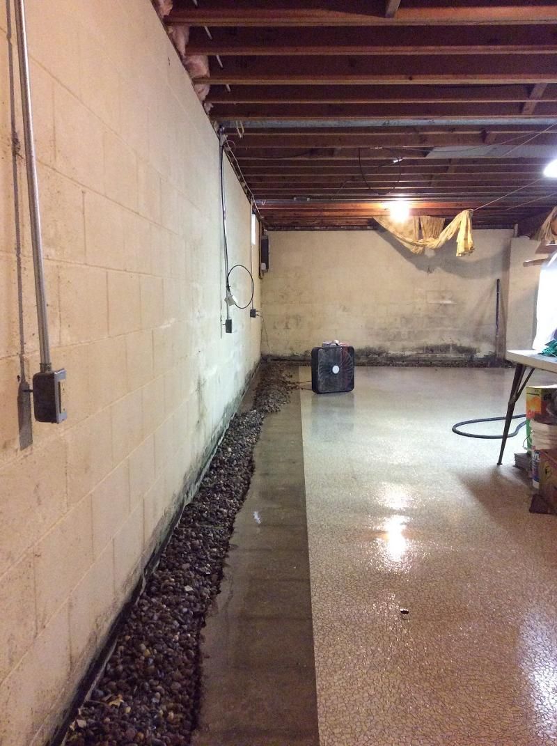 A basement with a table and a vacuum cleaner in it.