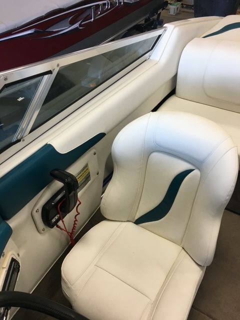 The inside of a boat with white seats and blue trim