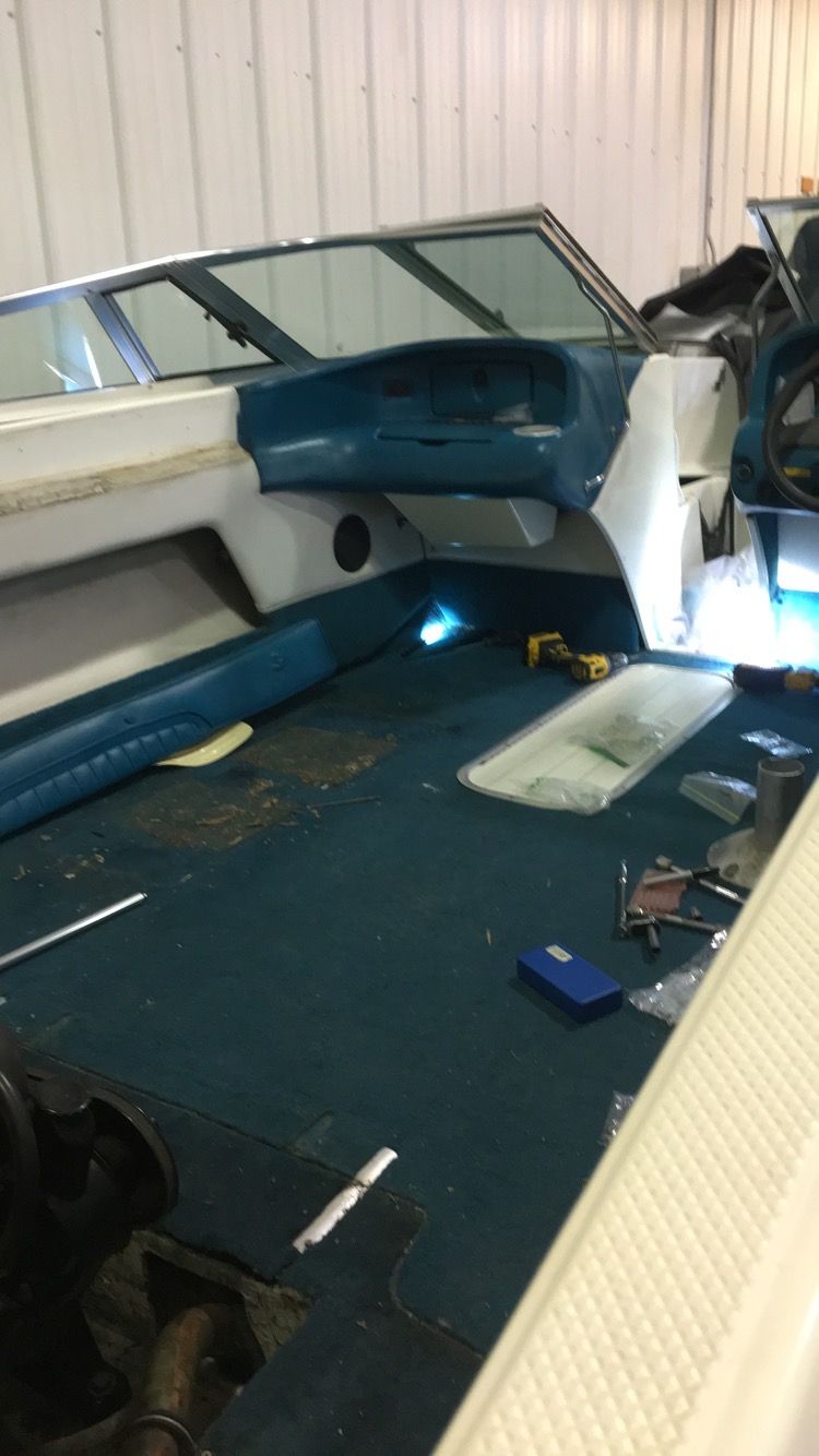 The inside of a boat is being repaired in a garage.