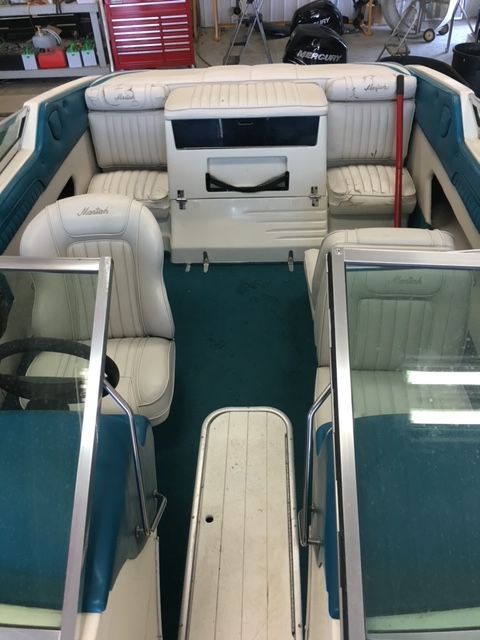 The inside of a boat with white seats and blue trim.