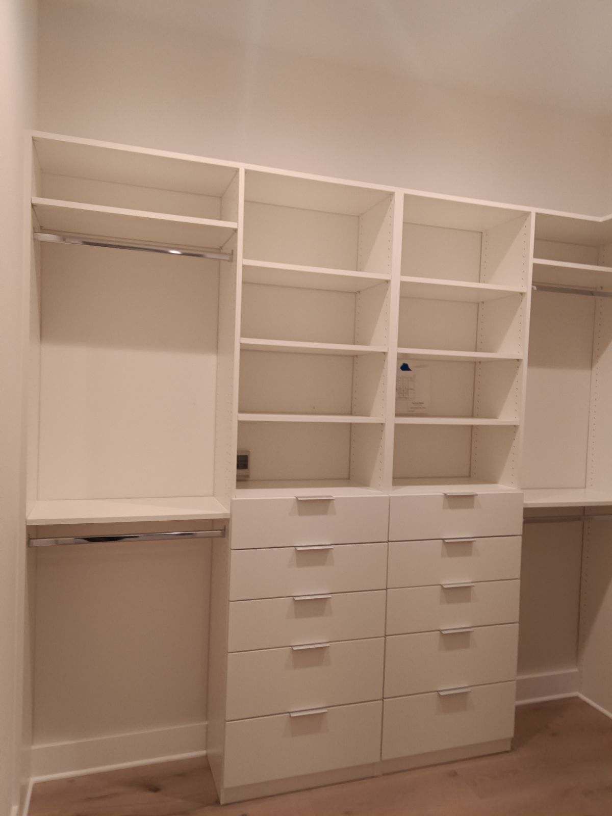 A walk in closet with lots of shelves and drawers.