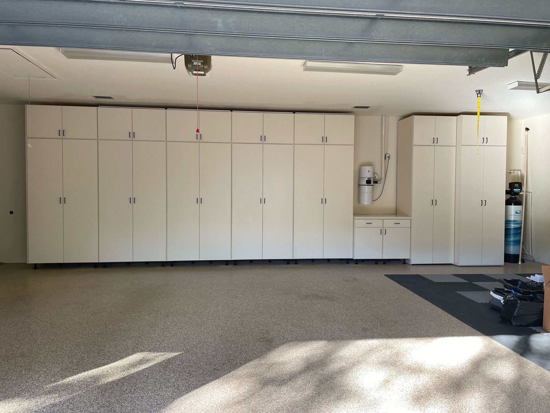 A garage with a lot of white cabinets on the wall
