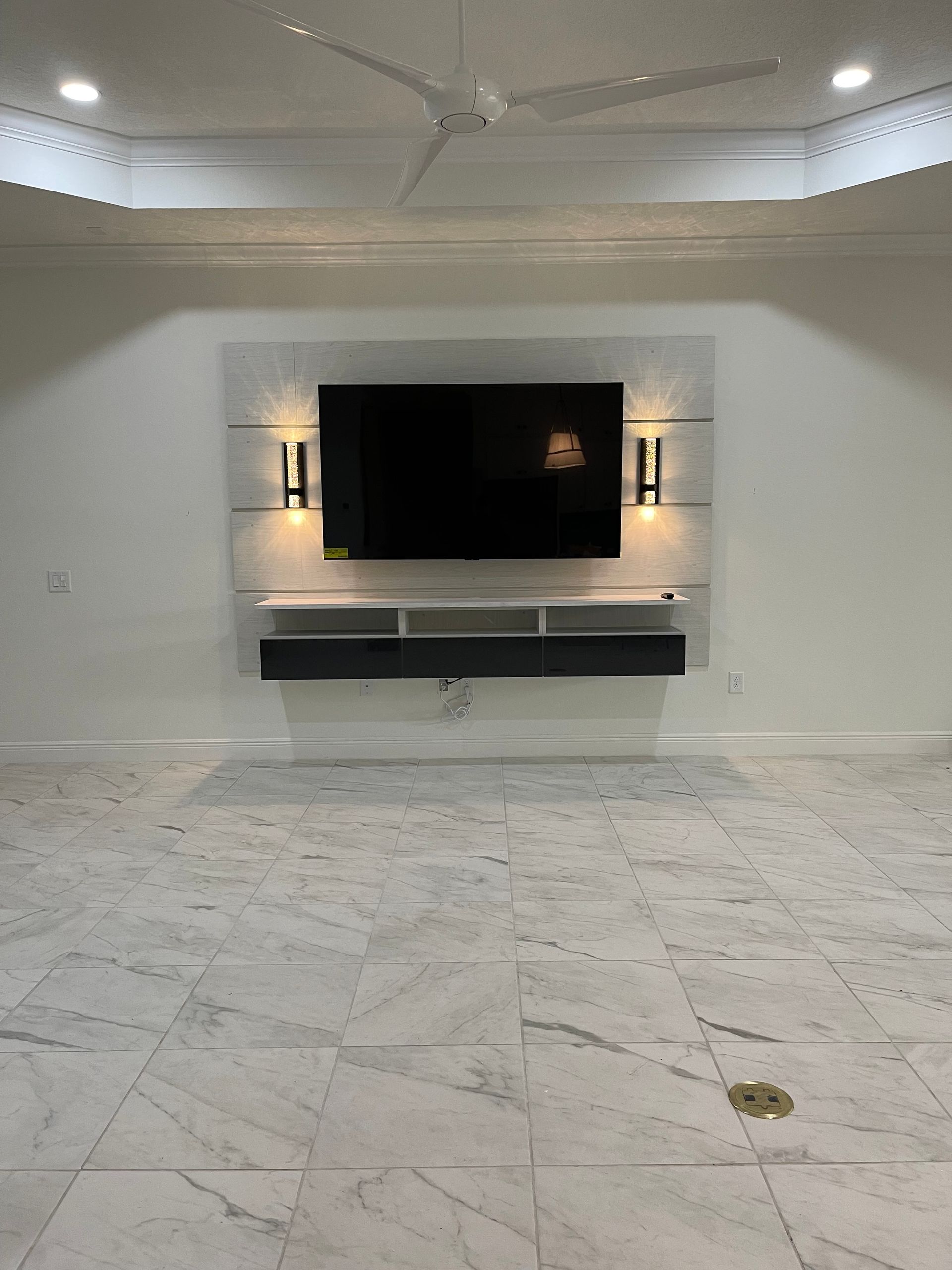 An empty room with a flat screen tv mounted on the wall.