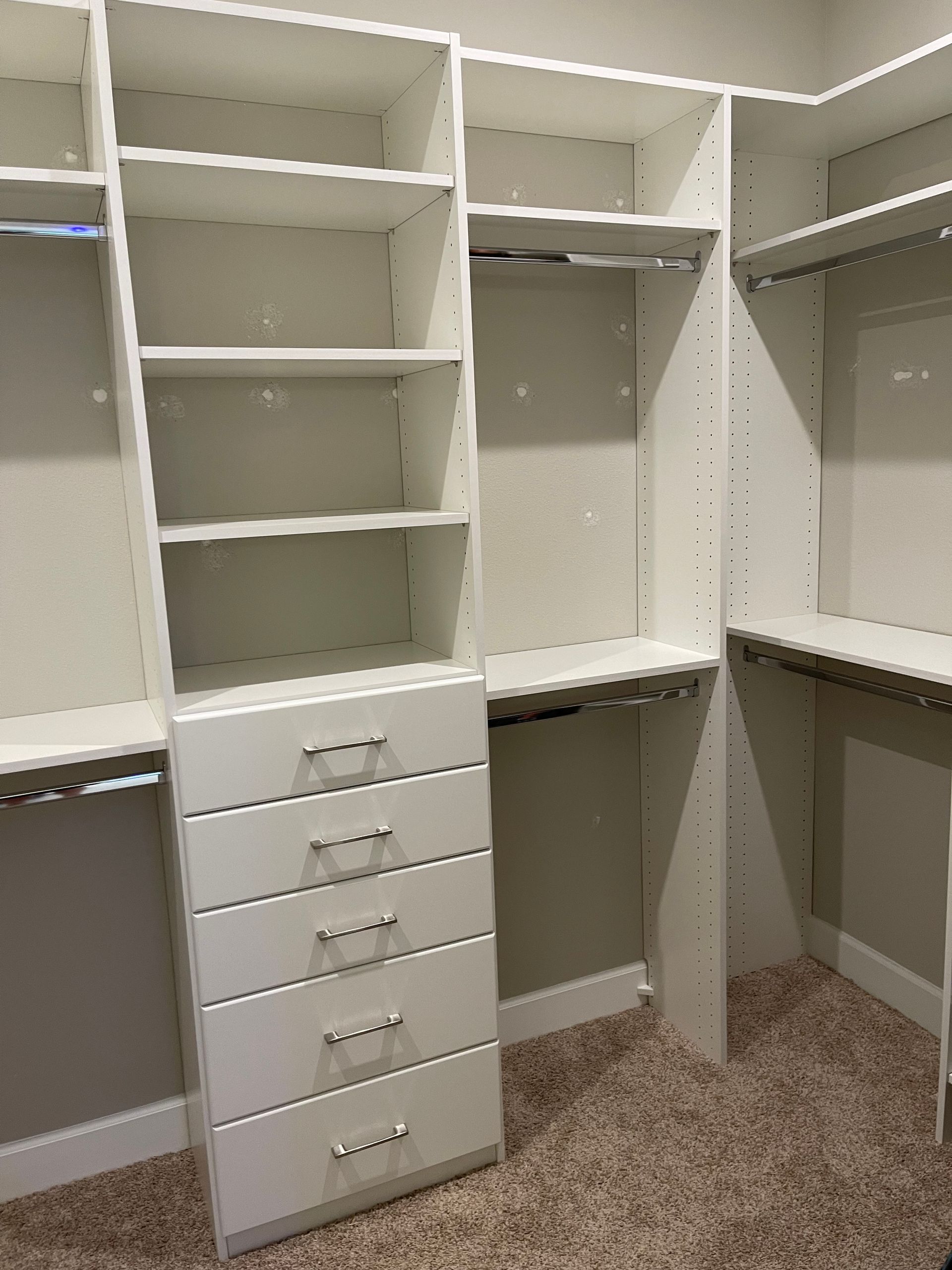 A walk in closet with lots of shelves and drawers.