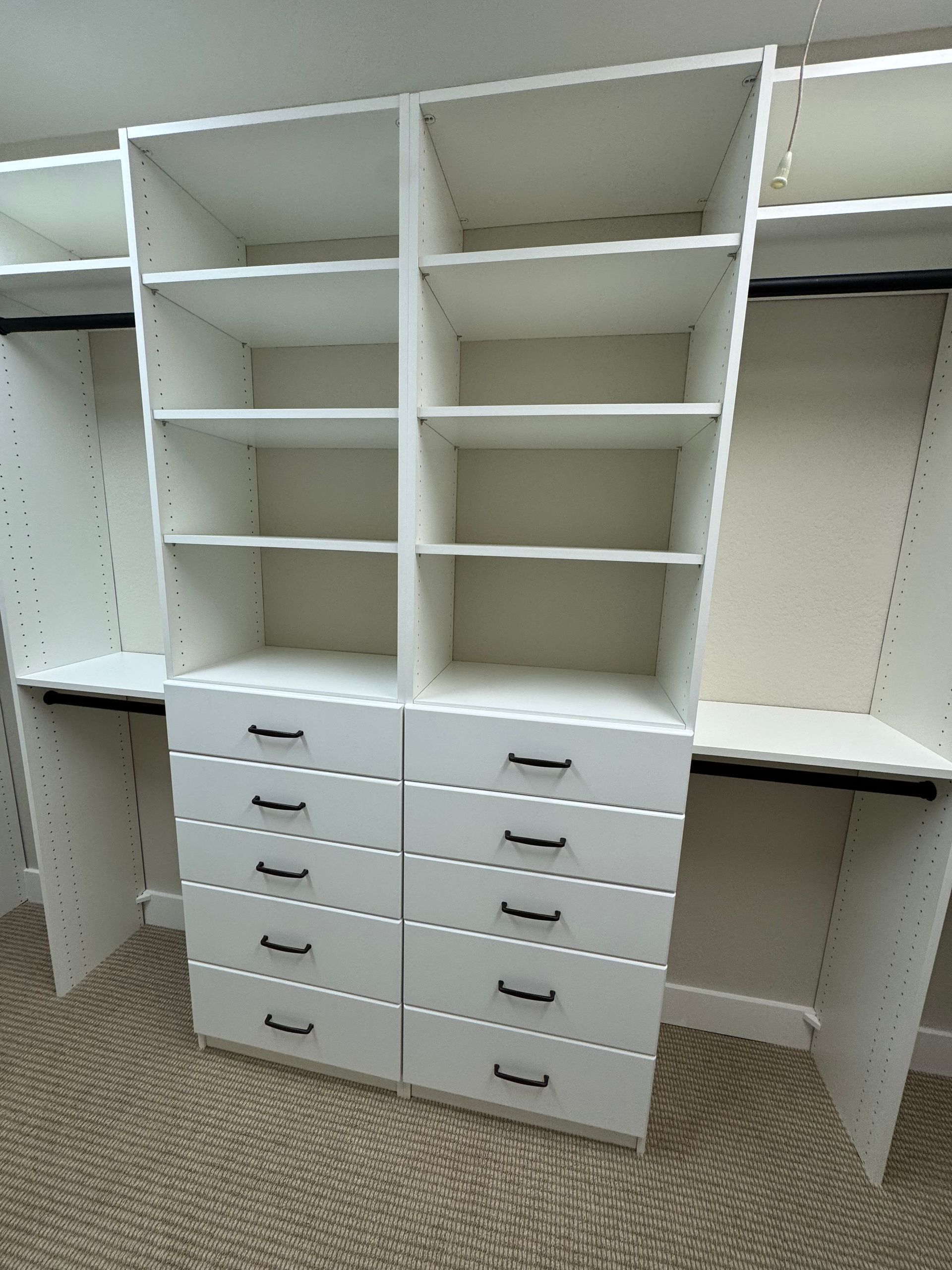 A walk in closet with lots of shelves and drawers