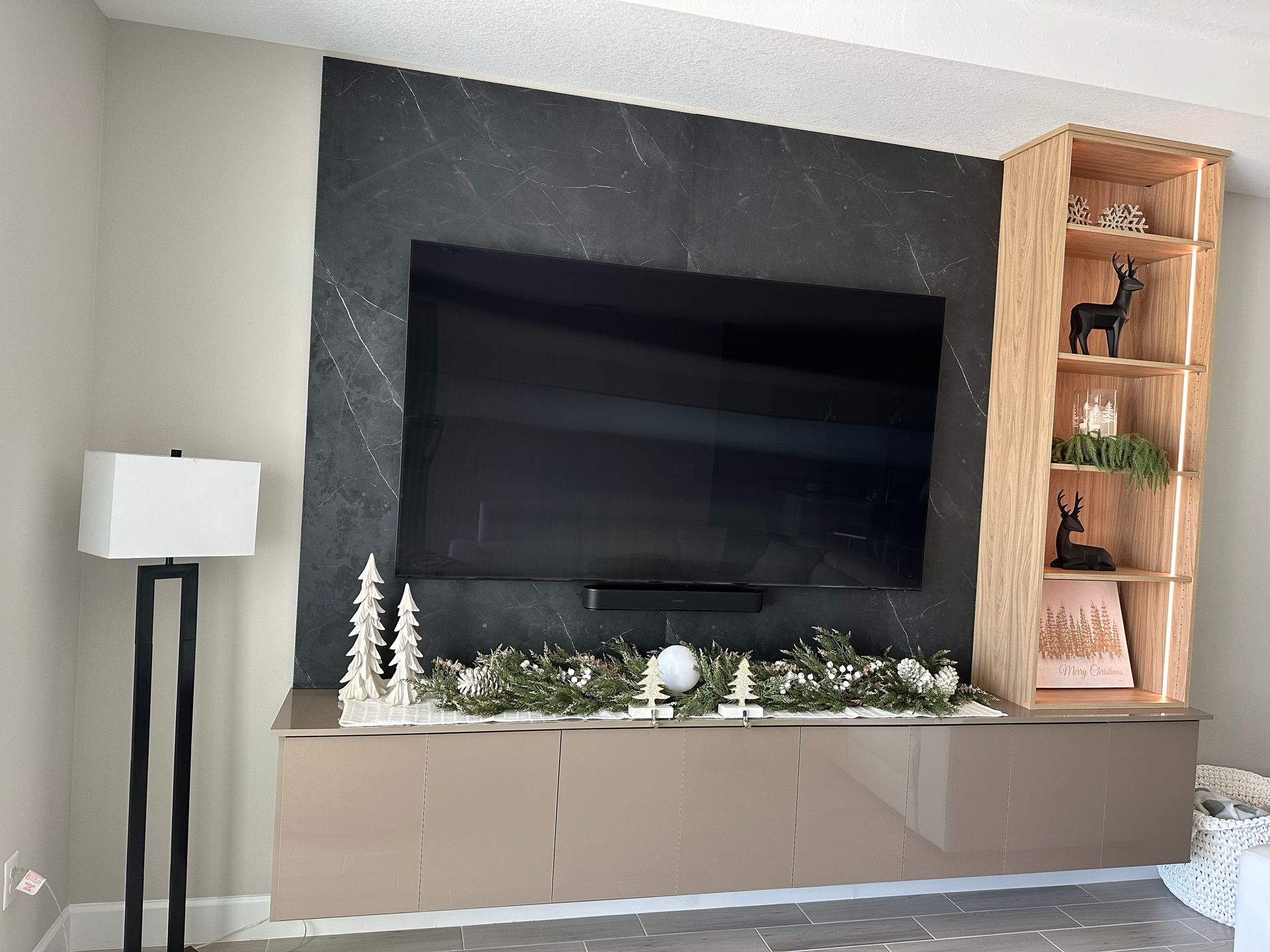 A living room with a large flat screen tv and a lamp.