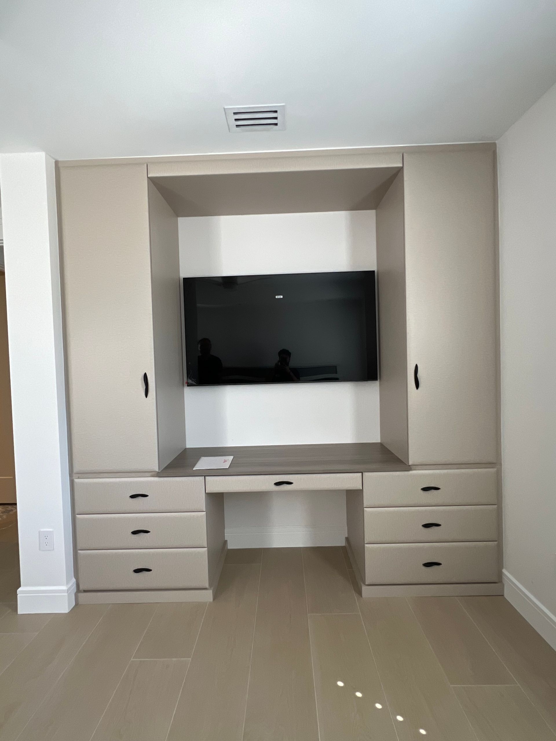 A bedroom with a desk and a flat screen tv