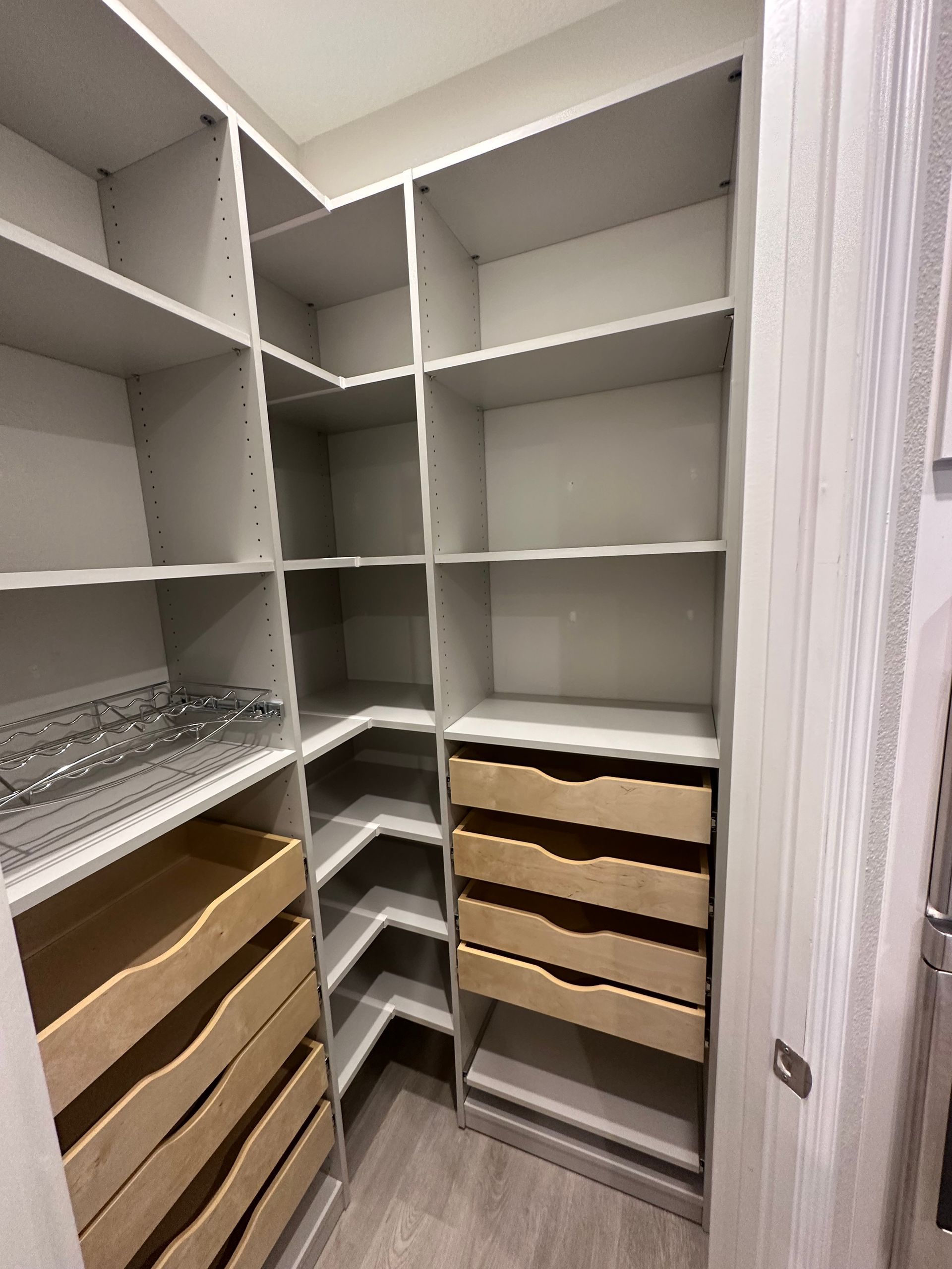 A walk in closet with lots of shelves and drawers.