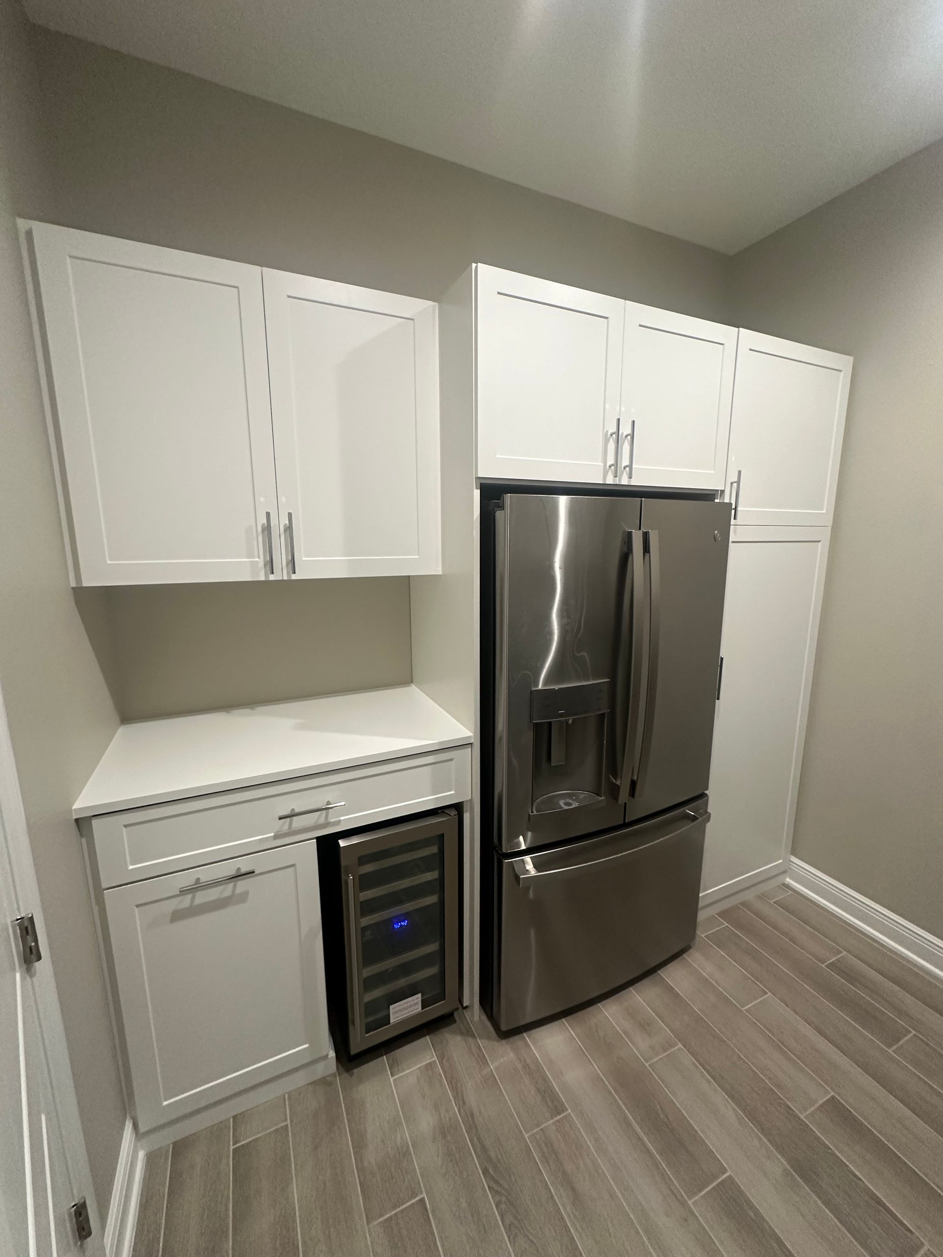 A kitchen with stainless steel appliances and white cabinets.
