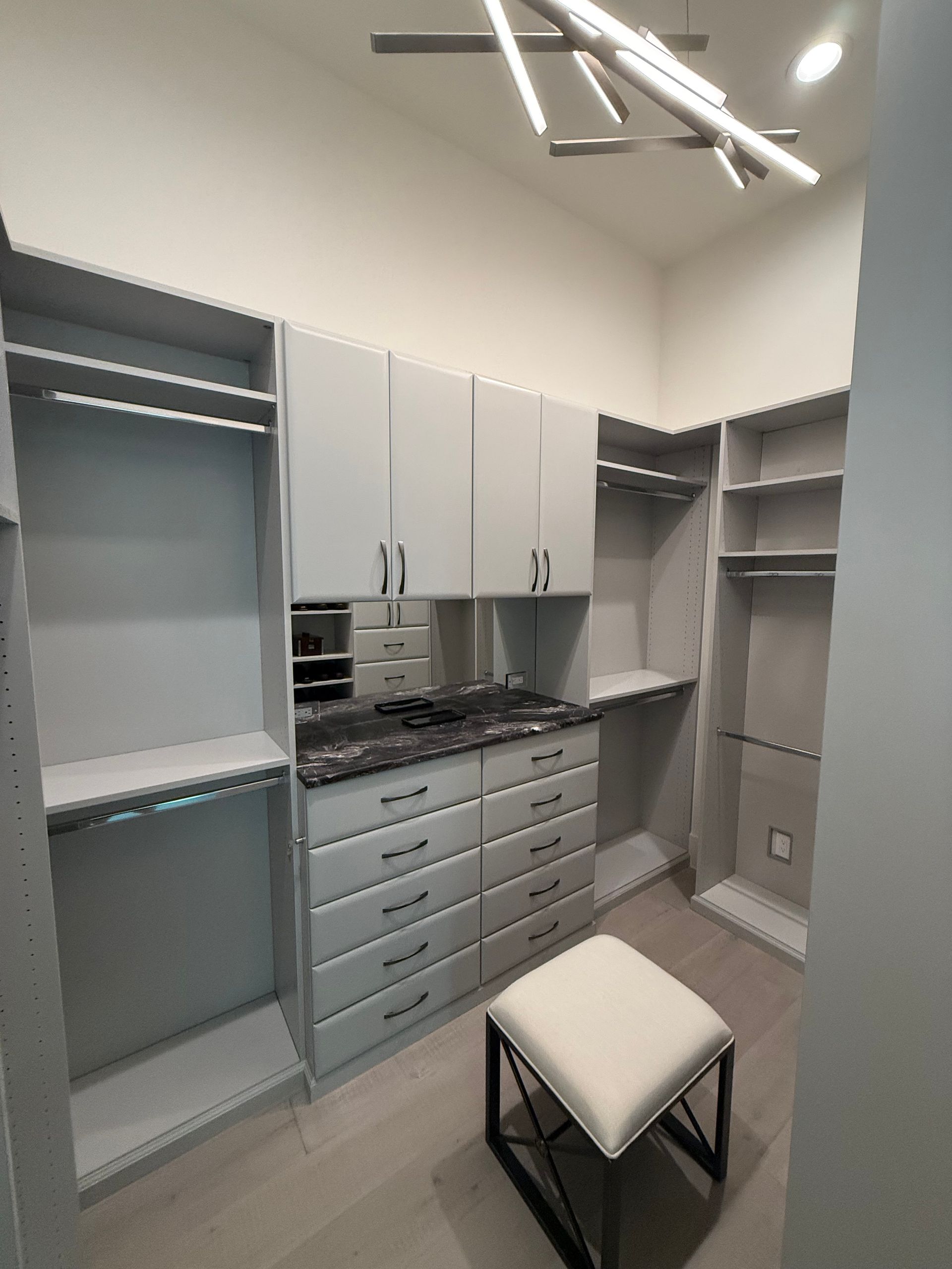 A walk in closet with lots of drawers and shelves