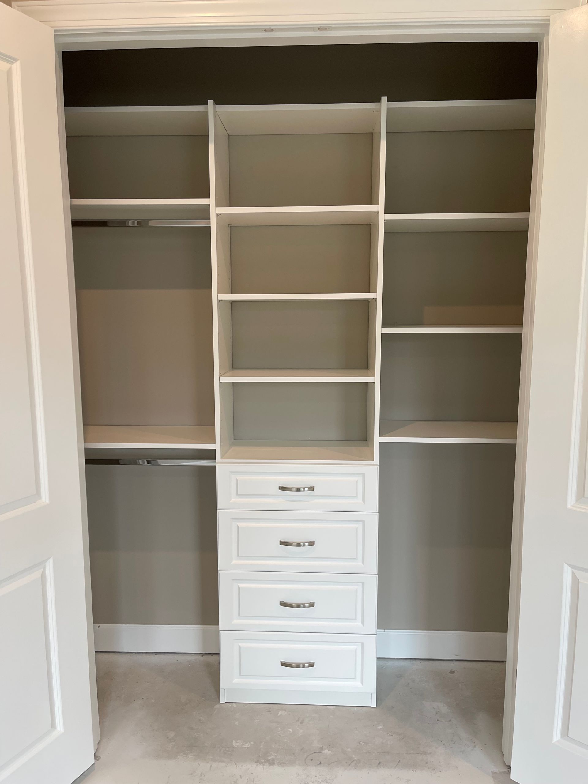 An empty walk in closet with shelves and drawers