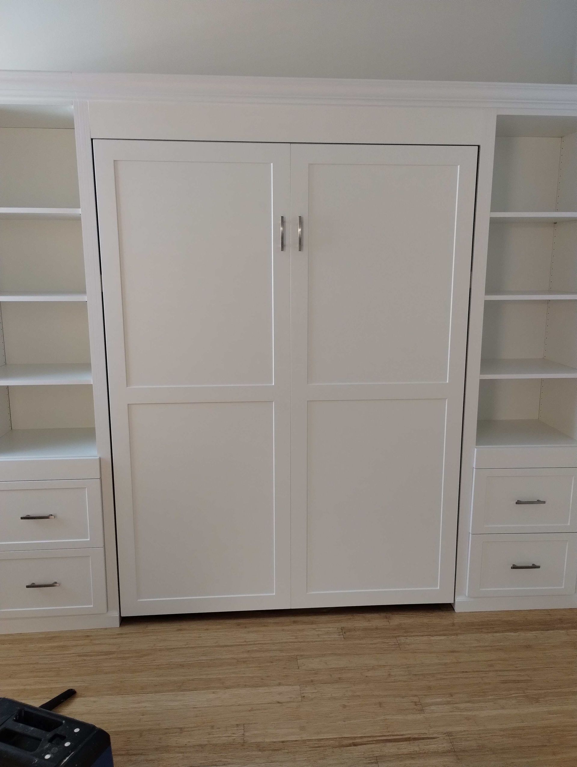 A room with lots of white cabinets and shelves