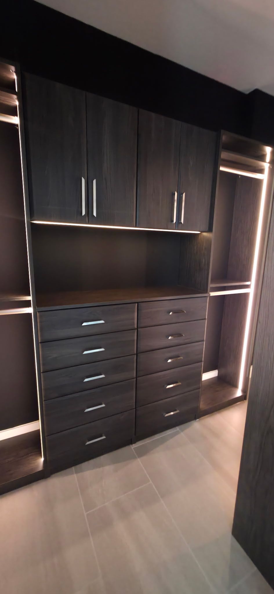 A walk in closet with lots of drawers and cabinets.