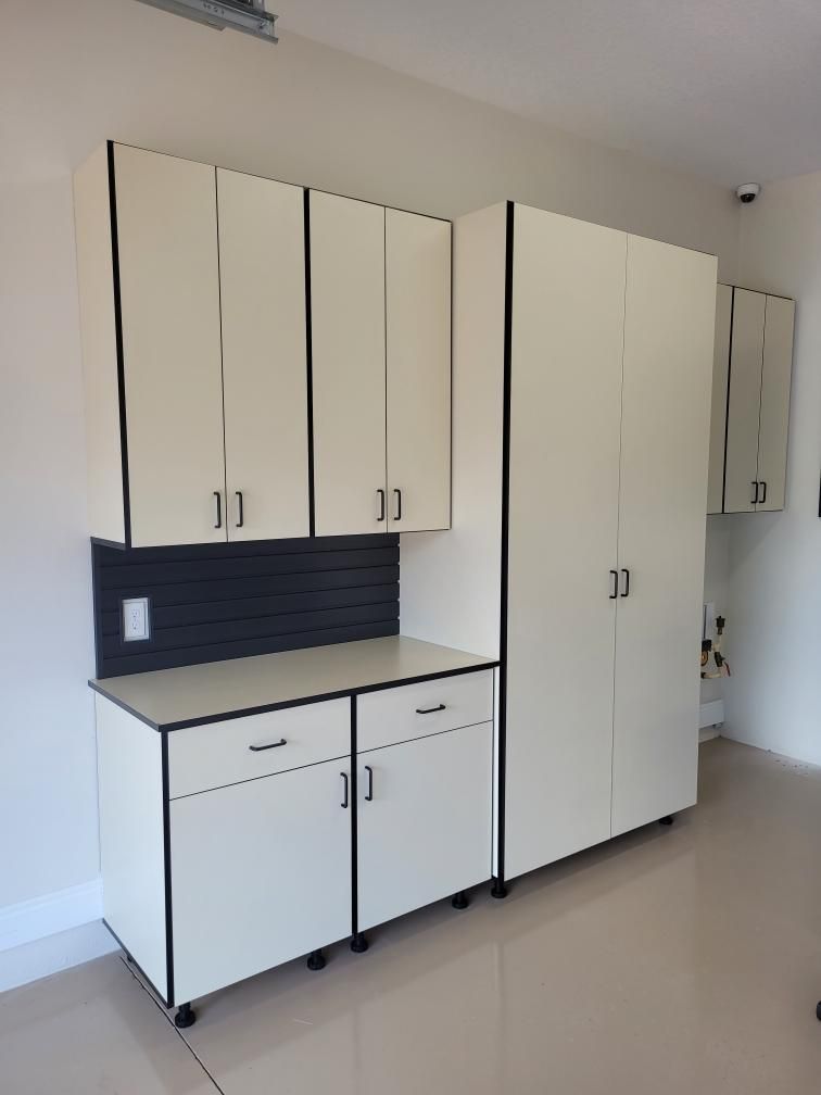 A kitchen with white cabinets and a counter top.