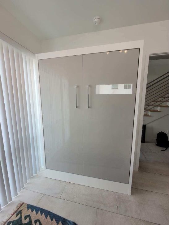 A bedroom with a gray wall mounted bed