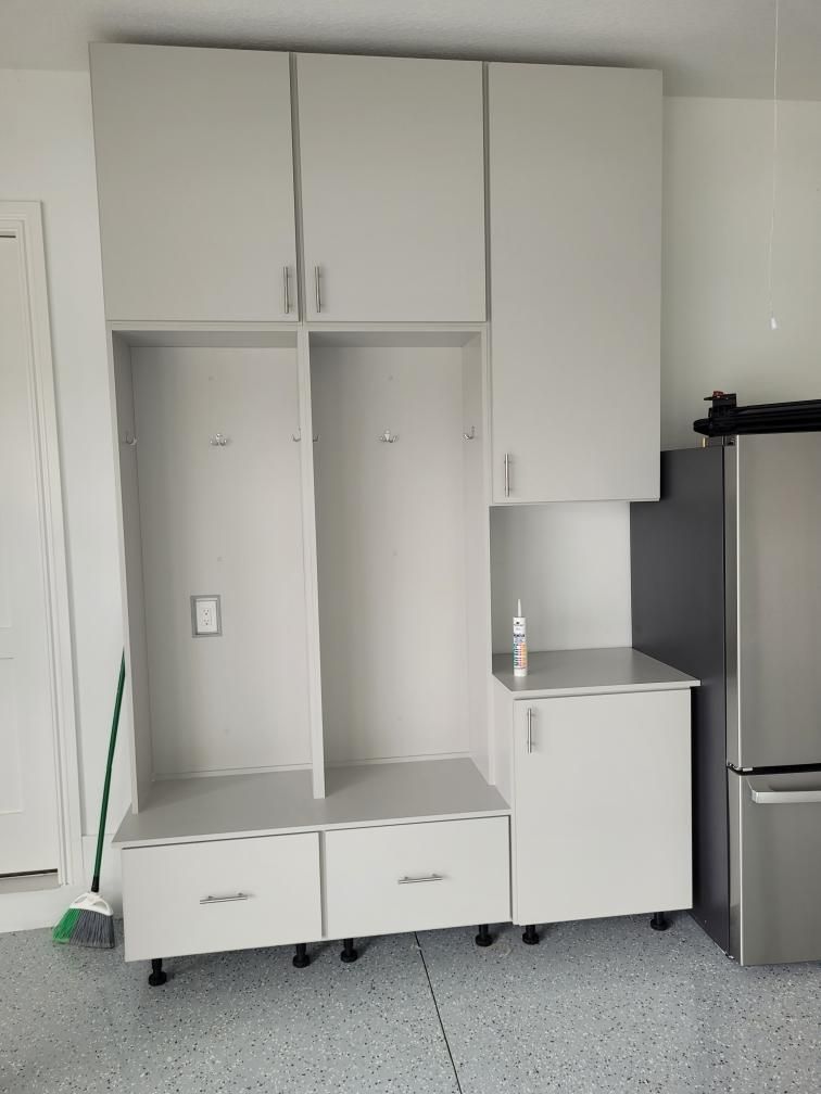 A kitchen with white cabinets and a stainless steel refrigerator