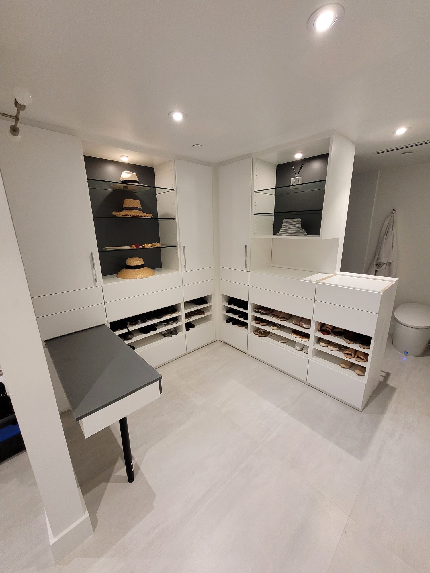 A large walk in closet with lots of shelves and drawers.