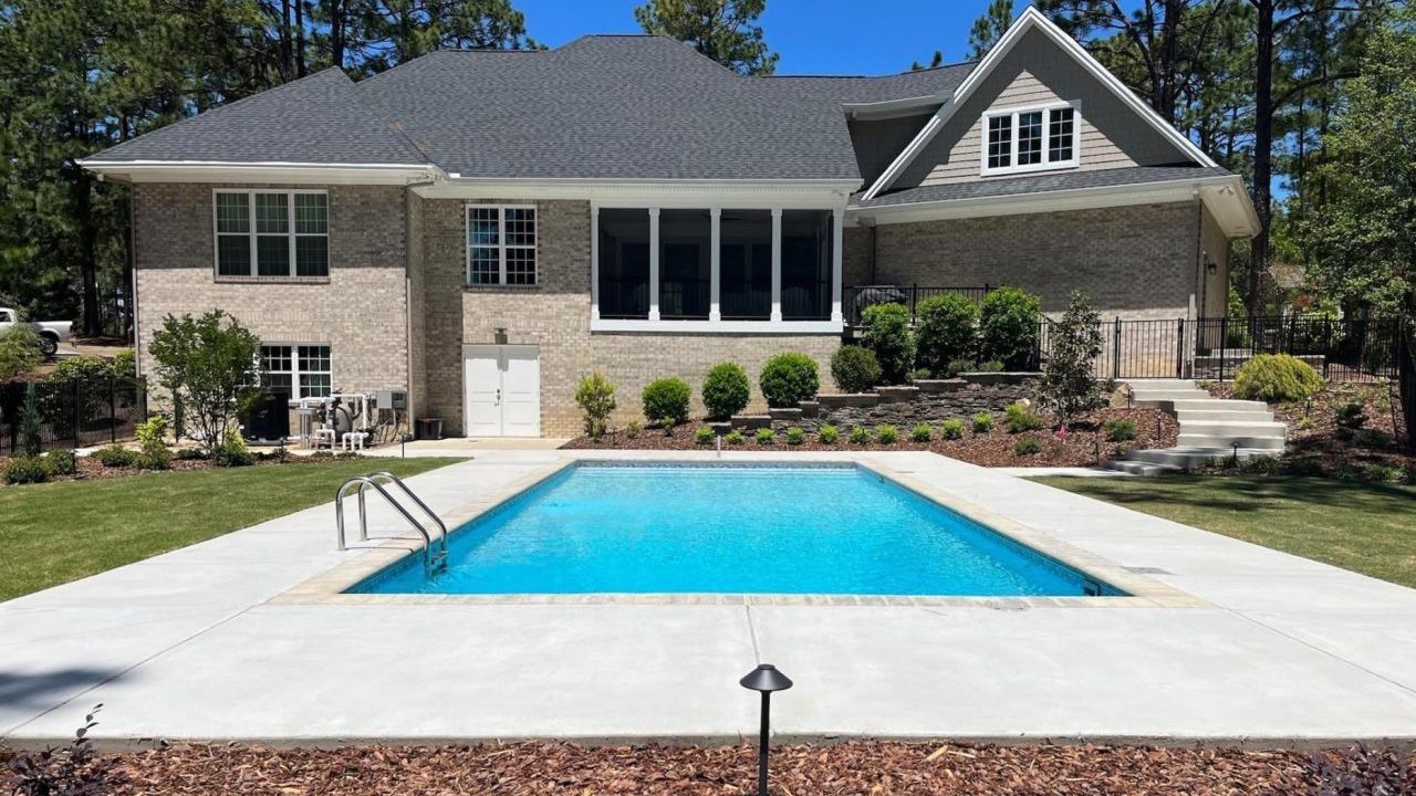 A large house with a large swimming pool in front of it.