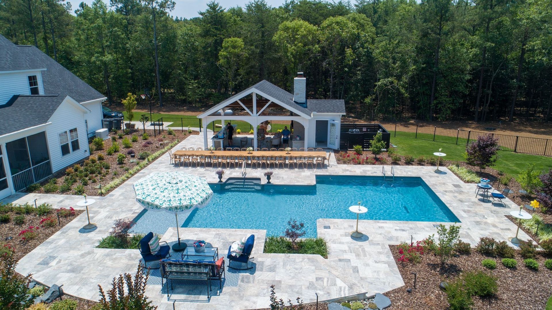 An aerial view of a large swimming pool in the backyard of a house